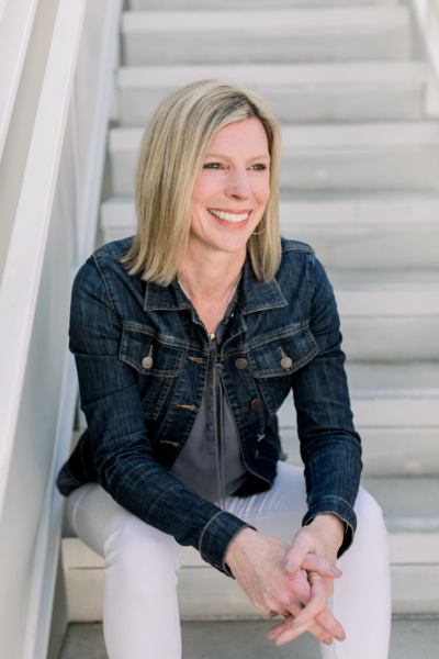 Laura Fravel sitting on stairs with a smile.