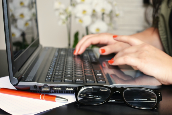 Hands typing an email on a laptop.