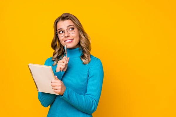 Photo of attractive business lady curly hairdo hold paper personal planner writing new novel chapter inspired look up wear specs blue turtleneck isolated bright yellow color background